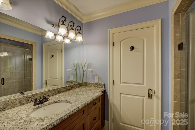 bathroom featuring a shower with shower door, vanity, and crown molding