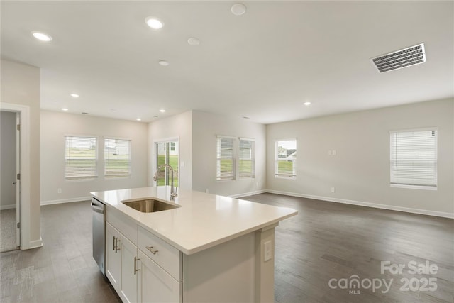 kitchen with dark hardwood / wood-style flooring, stainless steel dishwasher, a kitchen island with sink, sink, and white cabinets