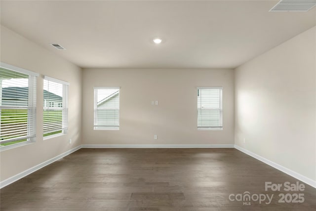 spare room with dark hardwood / wood-style floors and a wealth of natural light