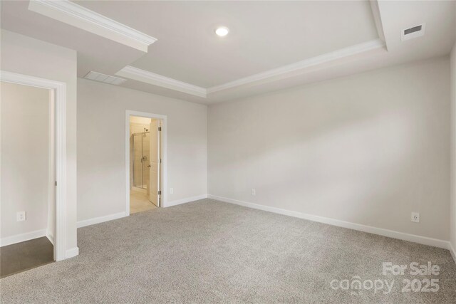 unfurnished bedroom featuring carpet flooring, ensuite bath, crown molding, and a tray ceiling