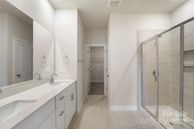 bathroom featuring tile patterned floors, vanity, and a shower with shower door