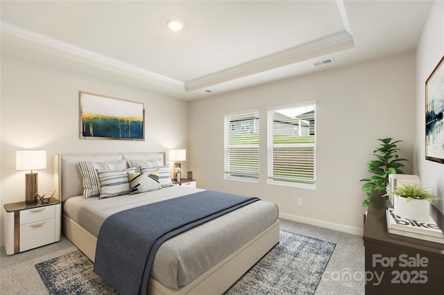 bedroom with carpet, ornamental molding, and a tray ceiling