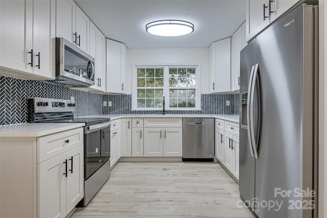 kitchen with stainless steel appliances, sink, and white cabinets