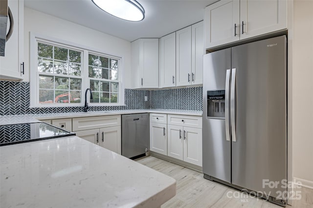 kitchen featuring appliances with stainless steel finishes, sink, decorative backsplash, and white cabinets