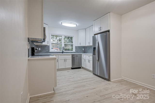 kitchen featuring tasteful backsplash, sink, stainless steel appliances, and white cabinets