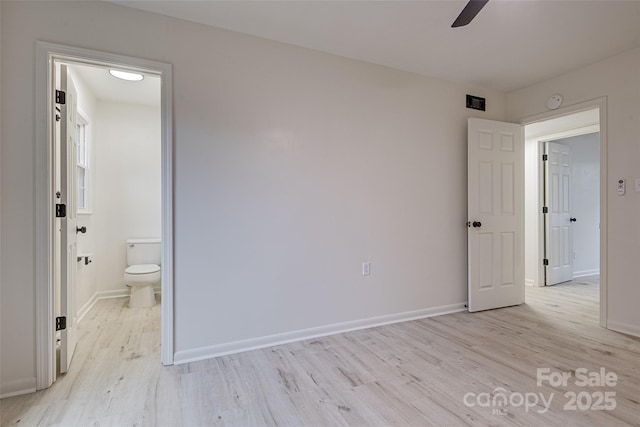 unfurnished bedroom with connected bathroom, light hardwood / wood-style floors, and ceiling fan