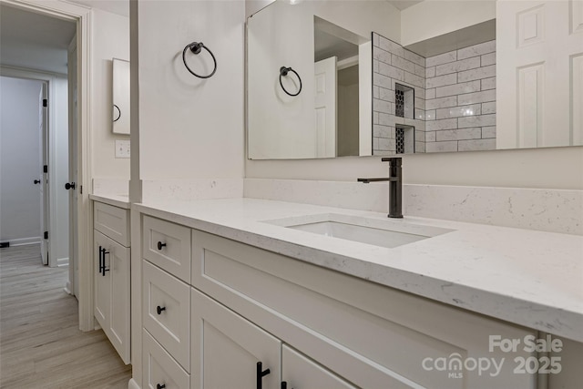 bathroom with hardwood / wood-style flooring and vanity