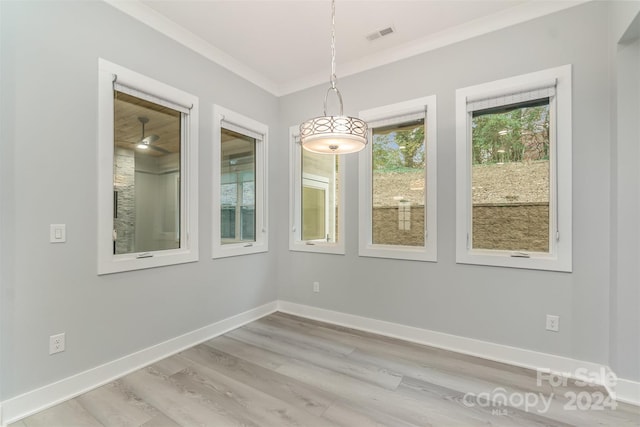 unfurnished dining area with light hardwood / wood-style flooring and ornamental molding