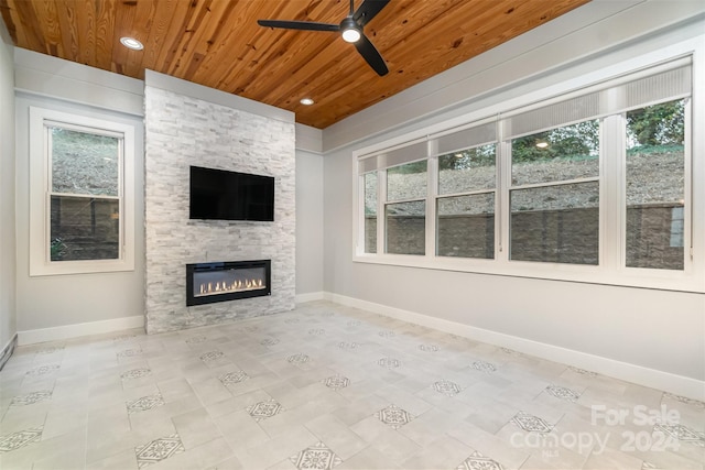 unfurnished living room featuring a fireplace, ceiling fan, and wood ceiling