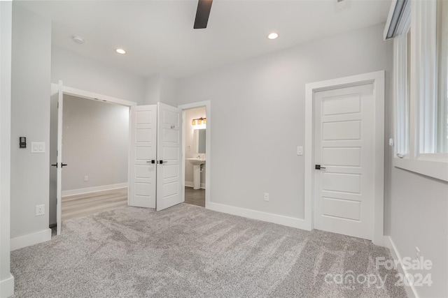 unfurnished bedroom featuring carpet flooring, connected bathroom, ceiling fan, and sink