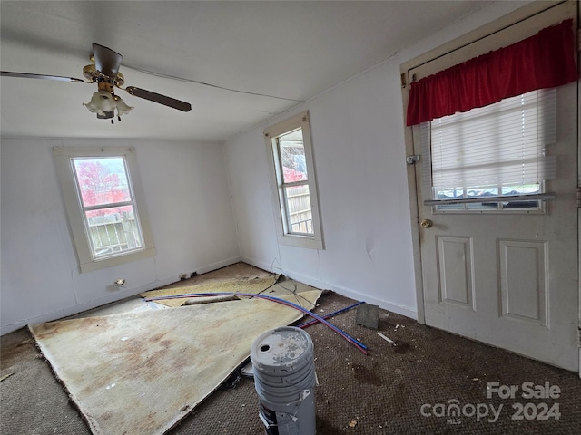 foyer with ceiling fan and carpet floors