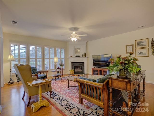 living room with ceiling fan, a healthy amount of sunlight, and light wood-type flooring