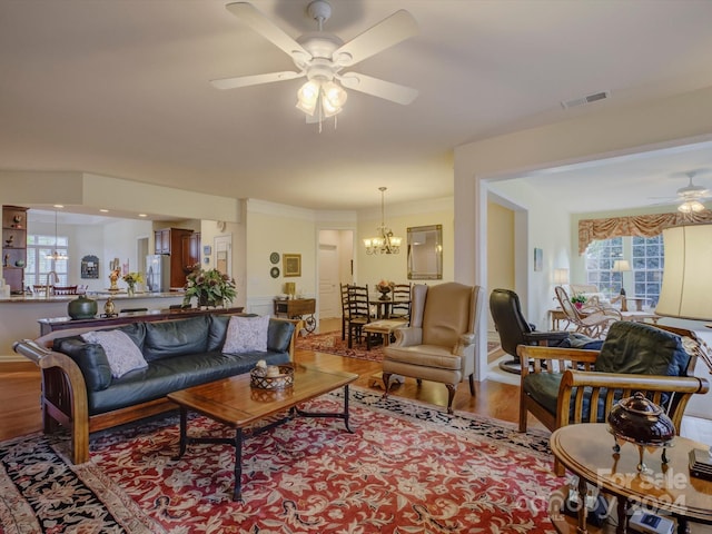 living room featuring hardwood / wood-style flooring and ceiling fan with notable chandelier