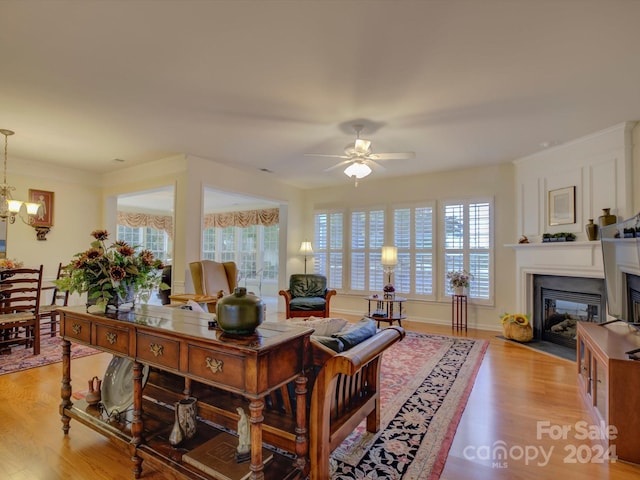 living room featuring ceiling fan with notable chandelier and light wood-type flooring