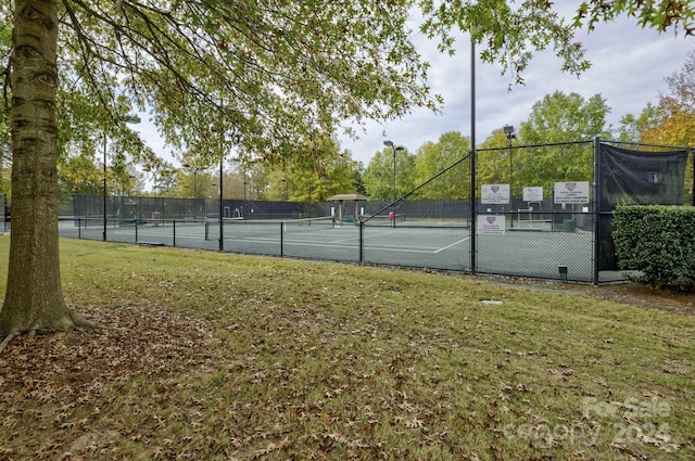 view of tennis court featuring a yard