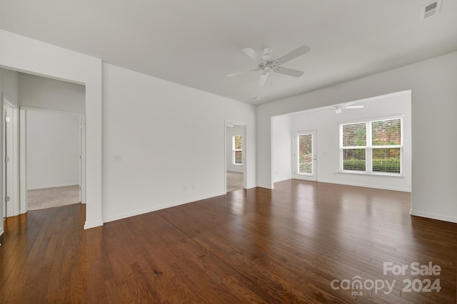 unfurnished living room with dark wood-type flooring and ceiling fan