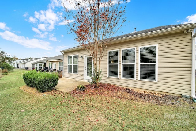 back of house with a yard and a patio area