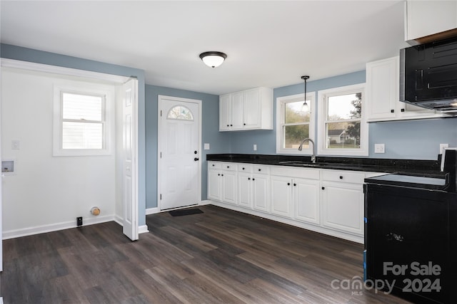 kitchen with dark wood-type flooring, white cabinetry, hanging light fixtures, and sink