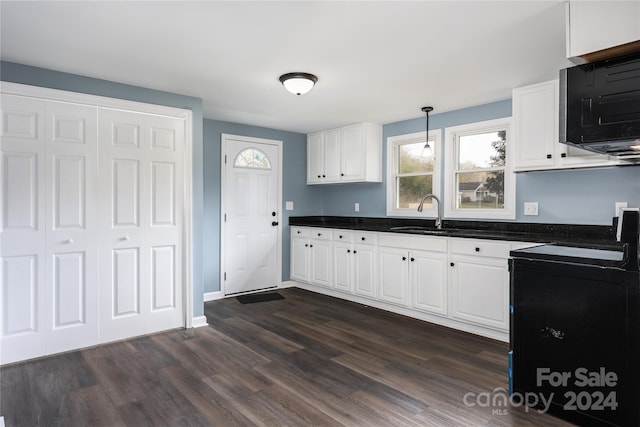 kitchen featuring white cabinets, dark hardwood / wood-style flooring, hanging light fixtures, and sink