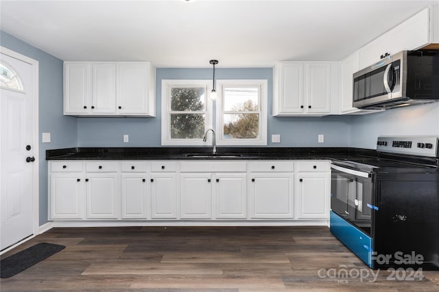 kitchen featuring black electric range, a healthy amount of sunlight, white cabinetry, and sink