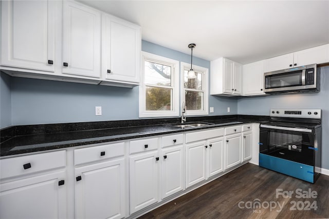 kitchen featuring dark wood-type flooring, white cabinets, decorative light fixtures, and stainless steel appliances