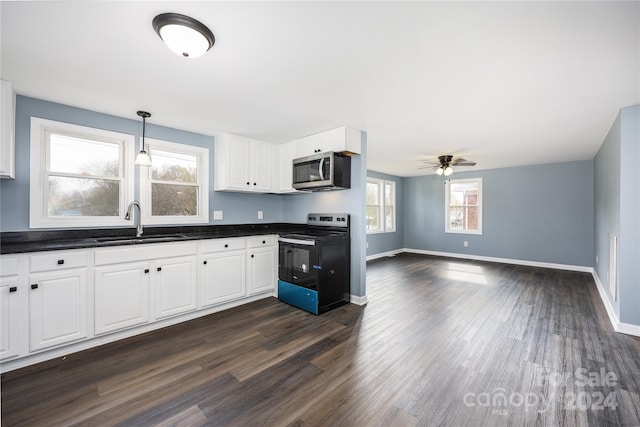 kitchen featuring a wealth of natural light, sink, black electric range oven, and white cabinets