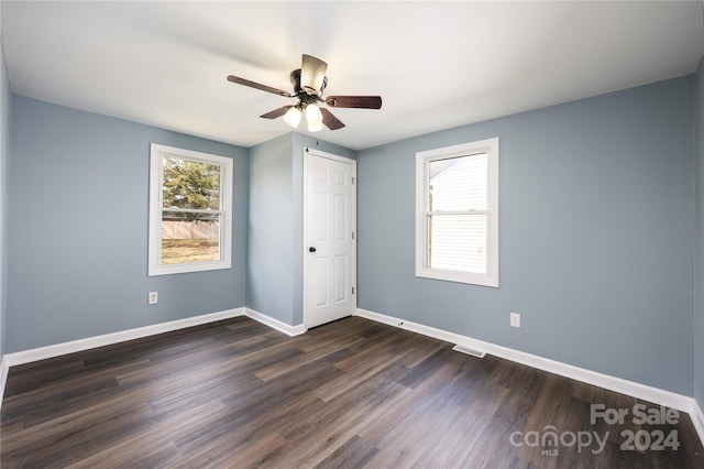 unfurnished bedroom with ceiling fan, dark hardwood / wood-style floors, and a closet