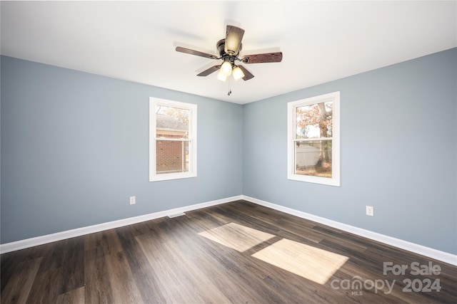 empty room with dark wood-type flooring and ceiling fan