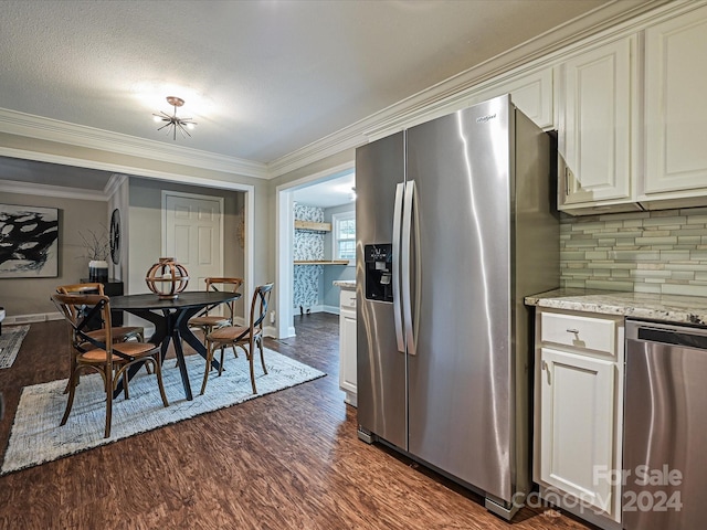 kitchen with appliances with stainless steel finishes, a textured ceiling, dark hardwood / wood-style floors, and ornamental molding