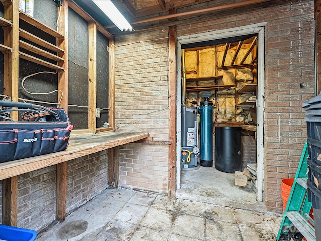 interior space featuring a workshop area, gas water heater, and brick wall