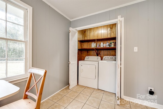 washroom with washer and clothes dryer, wood walls, light tile patterned floors, and ornamental molding