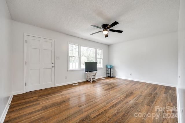 interior space with dark wood-type flooring, ceiling fan, and a textured ceiling