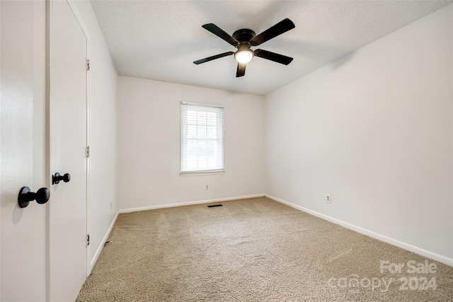 unfurnished room with a textured ceiling, carpet flooring, and ceiling fan