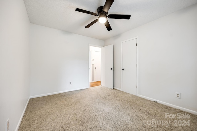 unfurnished bedroom featuring a textured ceiling, carpet, and ceiling fan