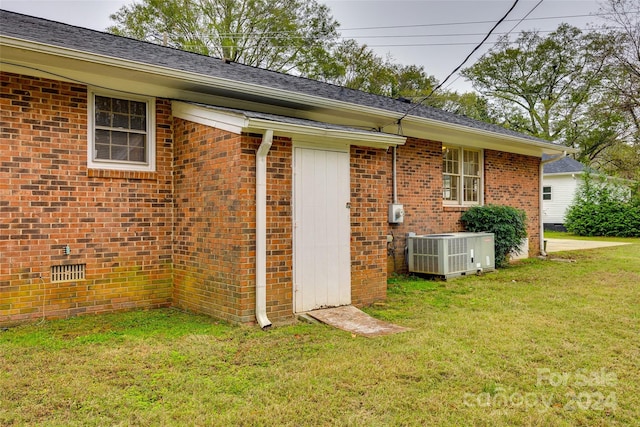 view of property exterior featuring central air condition unit and a lawn