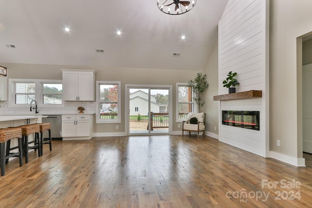 living room with hardwood / wood-style floors, a fireplace, high vaulted ceiling, and a chandelier