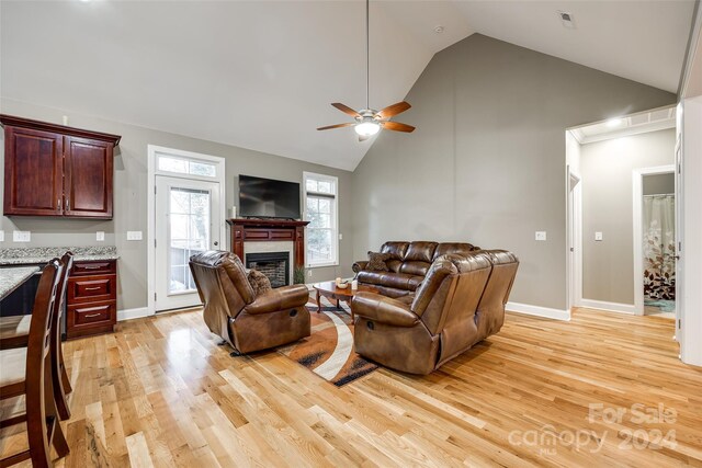 living room with high vaulted ceiling, ceiling fan, and light hardwood / wood-style floors