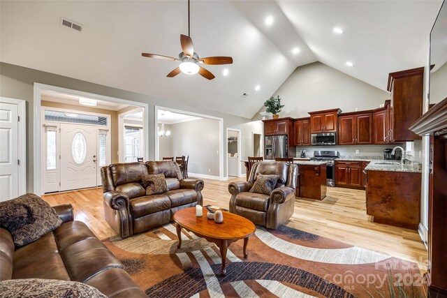 living room with high vaulted ceiling, sink, ceiling fan, and light hardwood / wood-style flooring