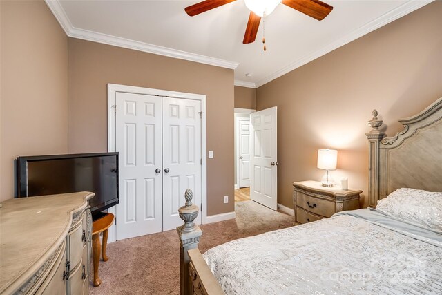 carpeted bedroom with ornamental molding, ceiling fan, and a closet