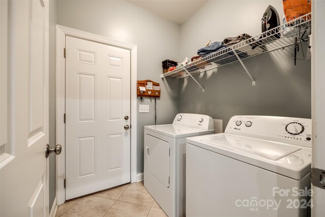 laundry area with washer and dryer and light tile patterned floors