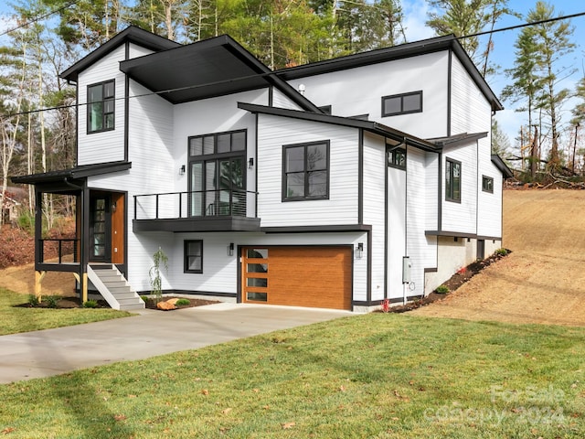 view of front of home with a balcony, a front lawn, and a garage