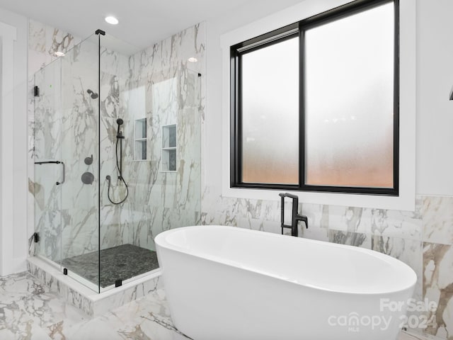 bathroom with shower with separate bathtub and tile walls