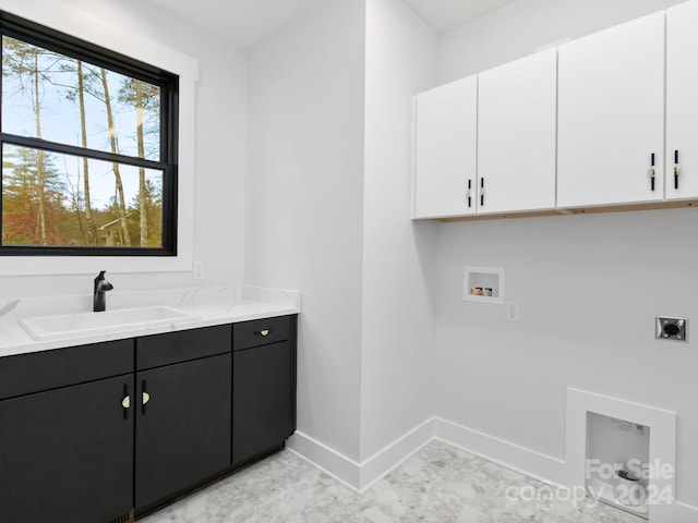 laundry area featuring electric dryer hookup, hookup for a washing machine, cabinets, and sink