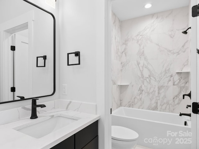 full bathroom featuring tiled shower / bath combo, vanity, and toilet