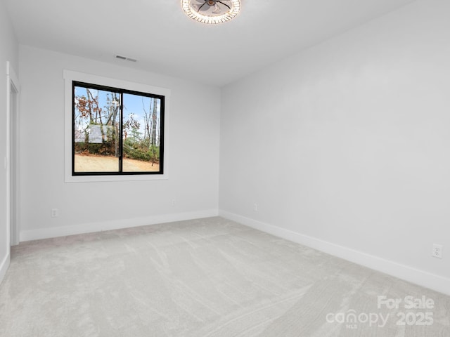 spare room featuring light colored carpet