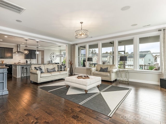 living room with dark wood-type flooring and crown molding