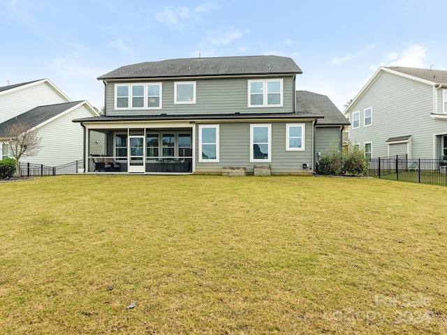 rear view of house featuring a sunroom and a yard