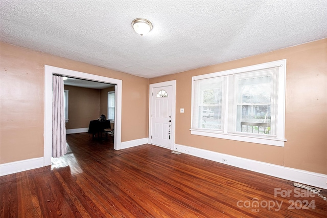 entrance foyer featuring a textured ceiling and dark hardwood / wood-style floors