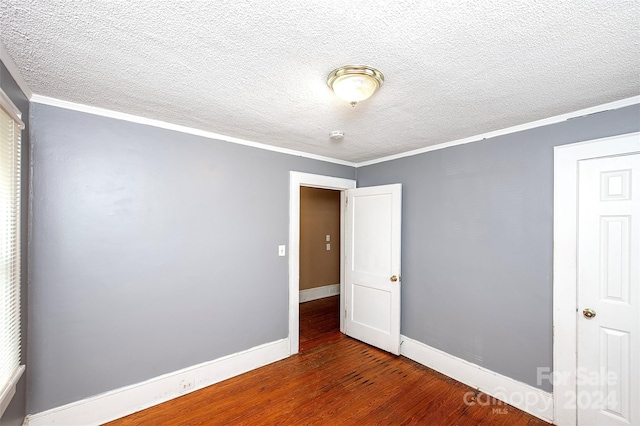 unfurnished room featuring dark hardwood / wood-style floors, a textured ceiling, and ornamental molding