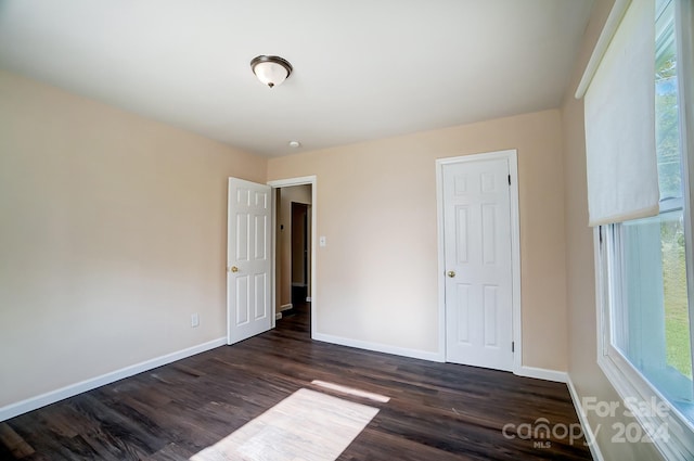 unfurnished bedroom featuring dark hardwood / wood-style floors and a closet